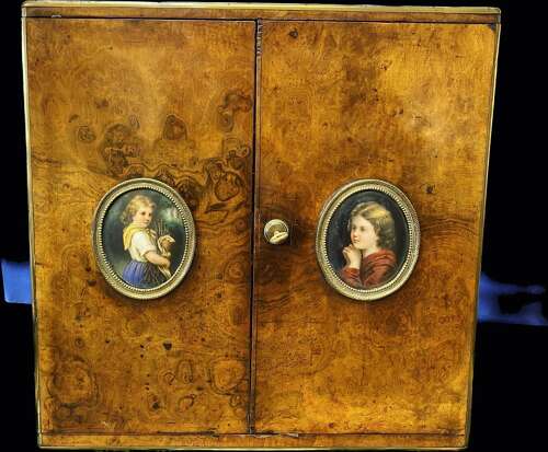 A figured walnut table cabinet with miniature portraits, circa 1870.