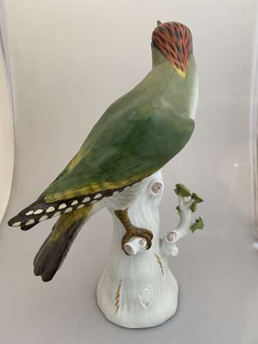A Meissen porcelain model of a Green woodpecker perched on a tree stump.