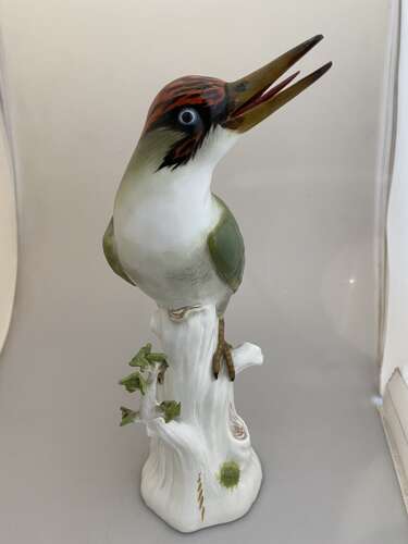 A Meissen porcelain model of a Green woodpecker perched on a tree stump.